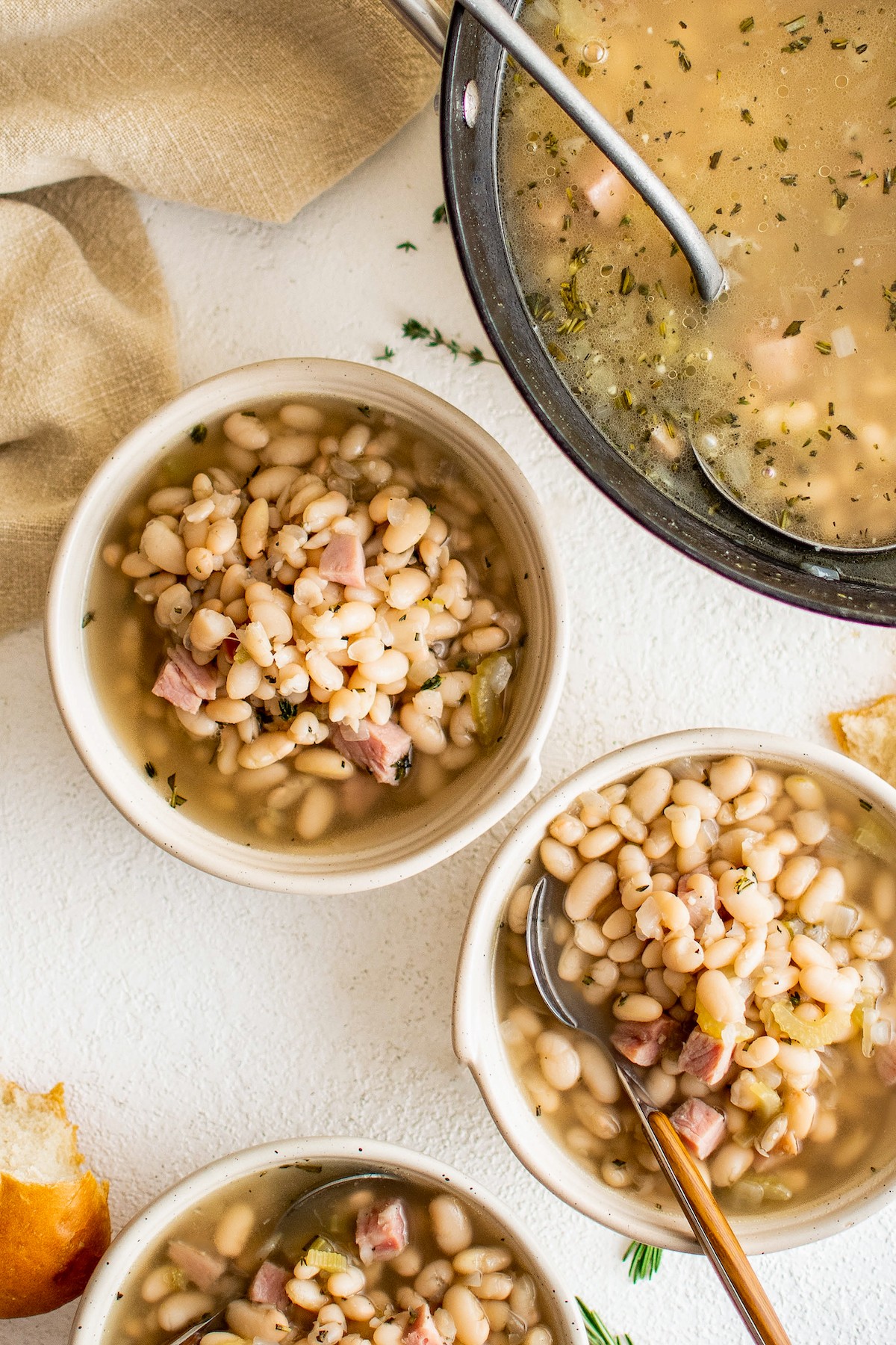 Three bowls of bean soup with ham.
