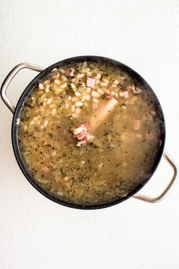 Ham and bean soup cooking in a pot.