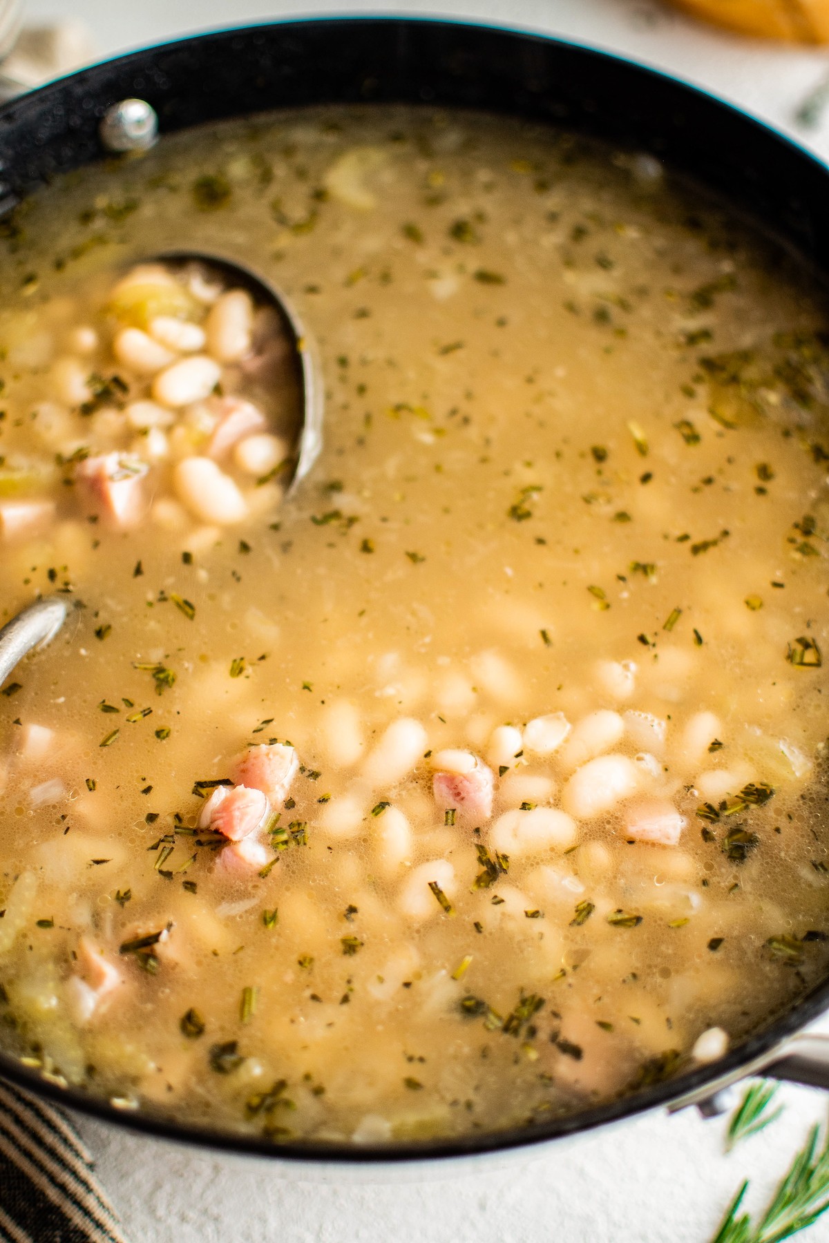 Ladle in a pot of bean soup.