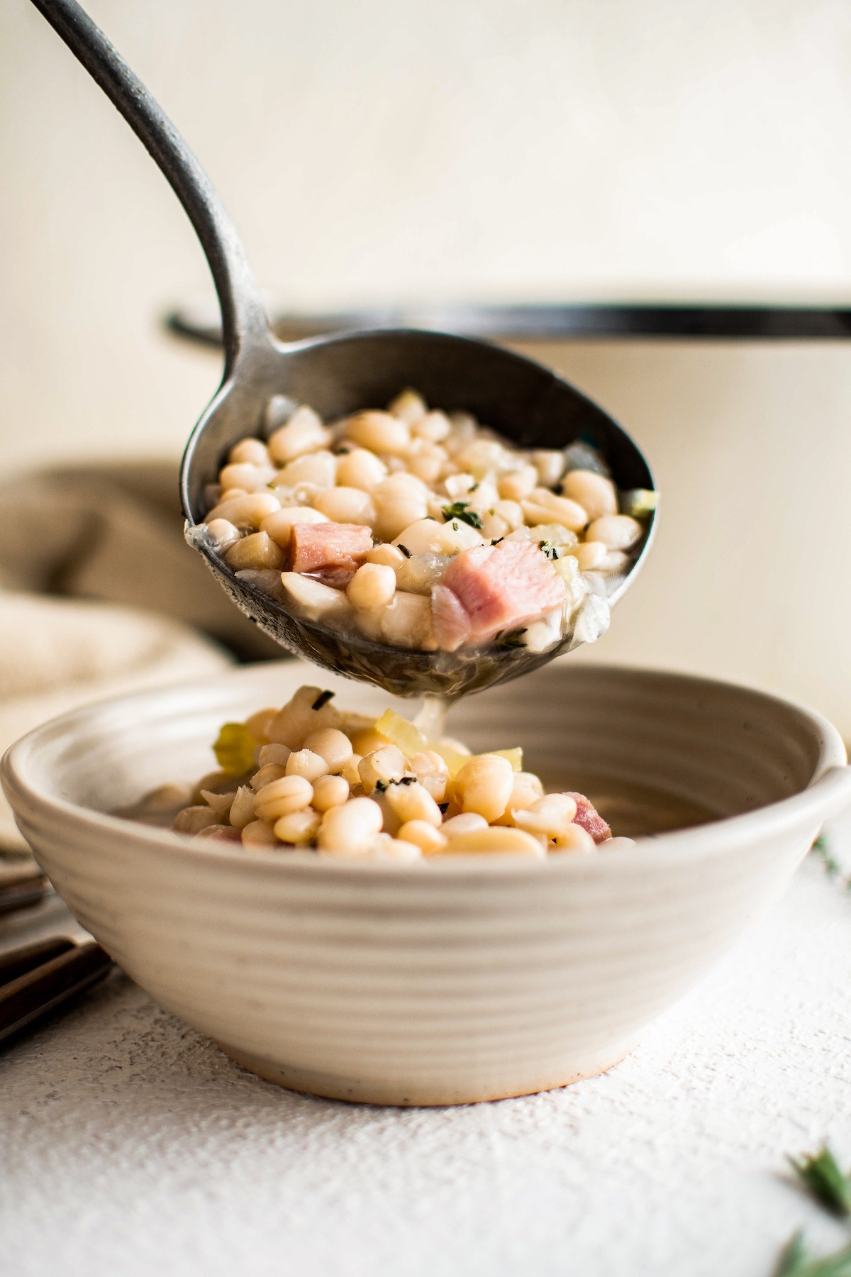Ham and bean soup ladled into a bowl.