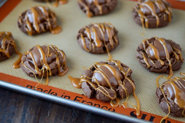 Turtle Chocolate Cookies in rows on a baking sheet topped with a caramel drizzle