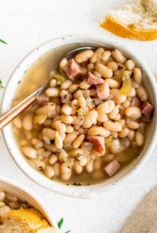 Bowl of ham and bean soup with fresh herbs.