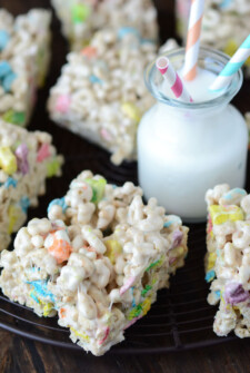 A Platter of Lucky Charm Marshmallow Treats Beside a Glass of Milk with Three Straws