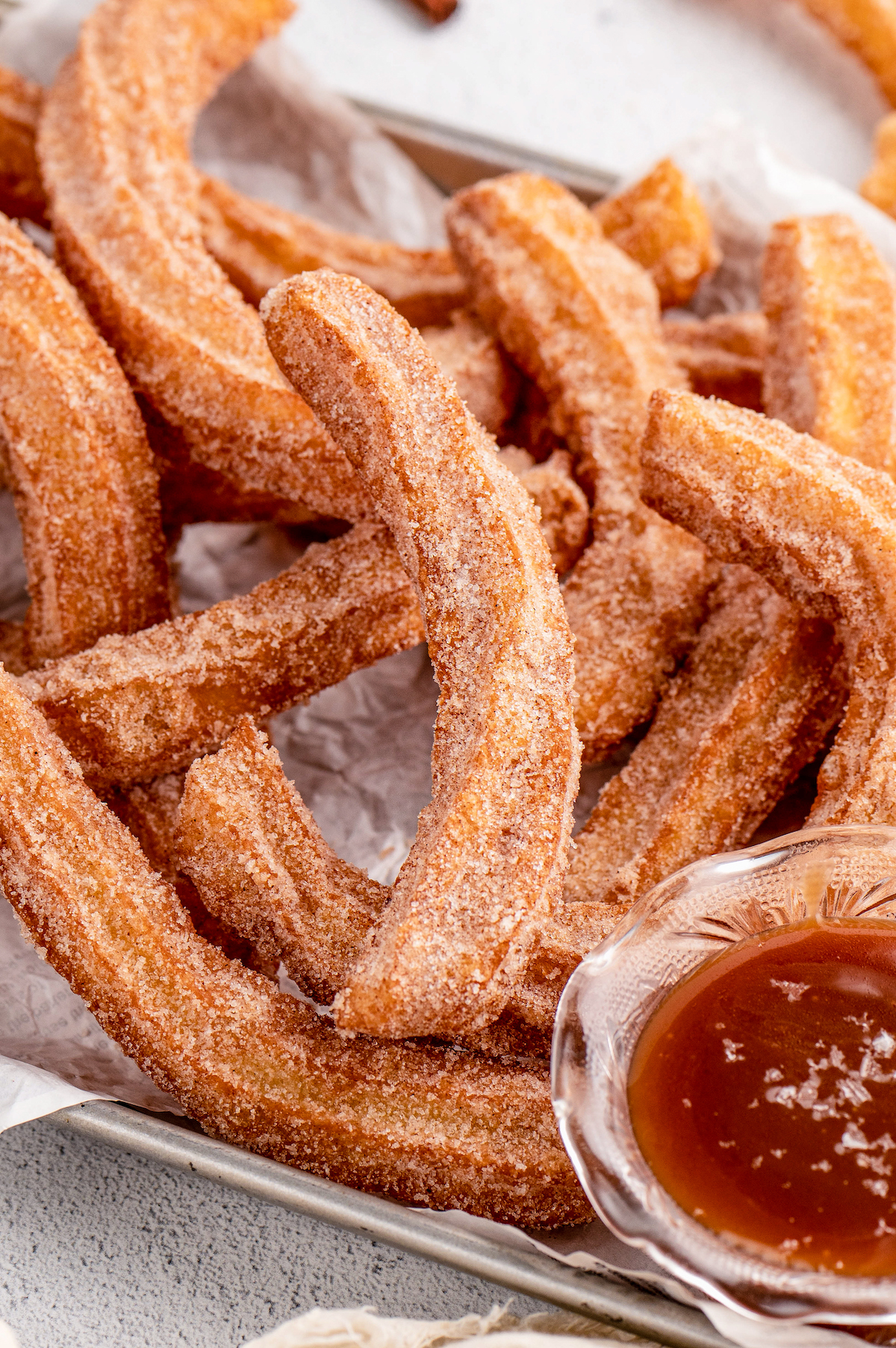Close-up of homamde churros with caramel sauce on the side.