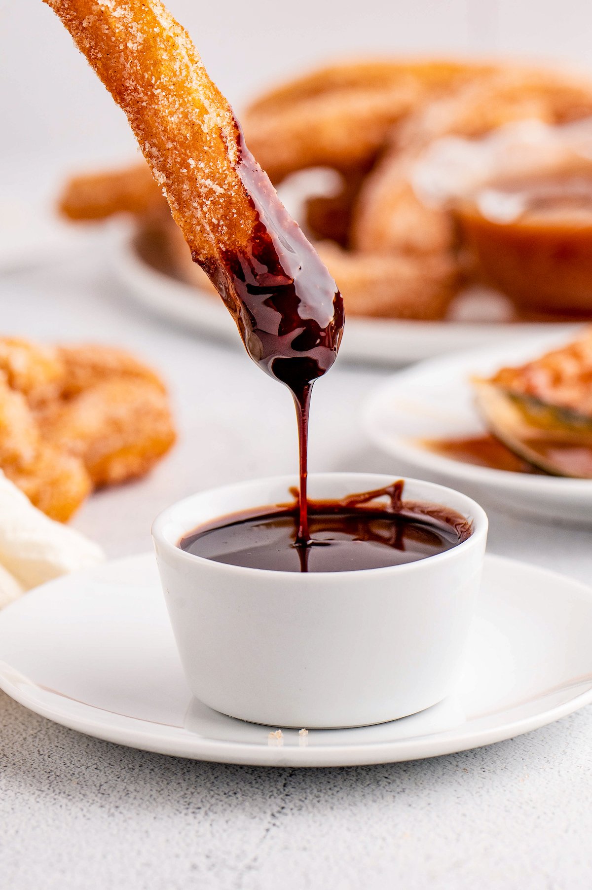 Dipping a homemade churro into chocolate sauce.