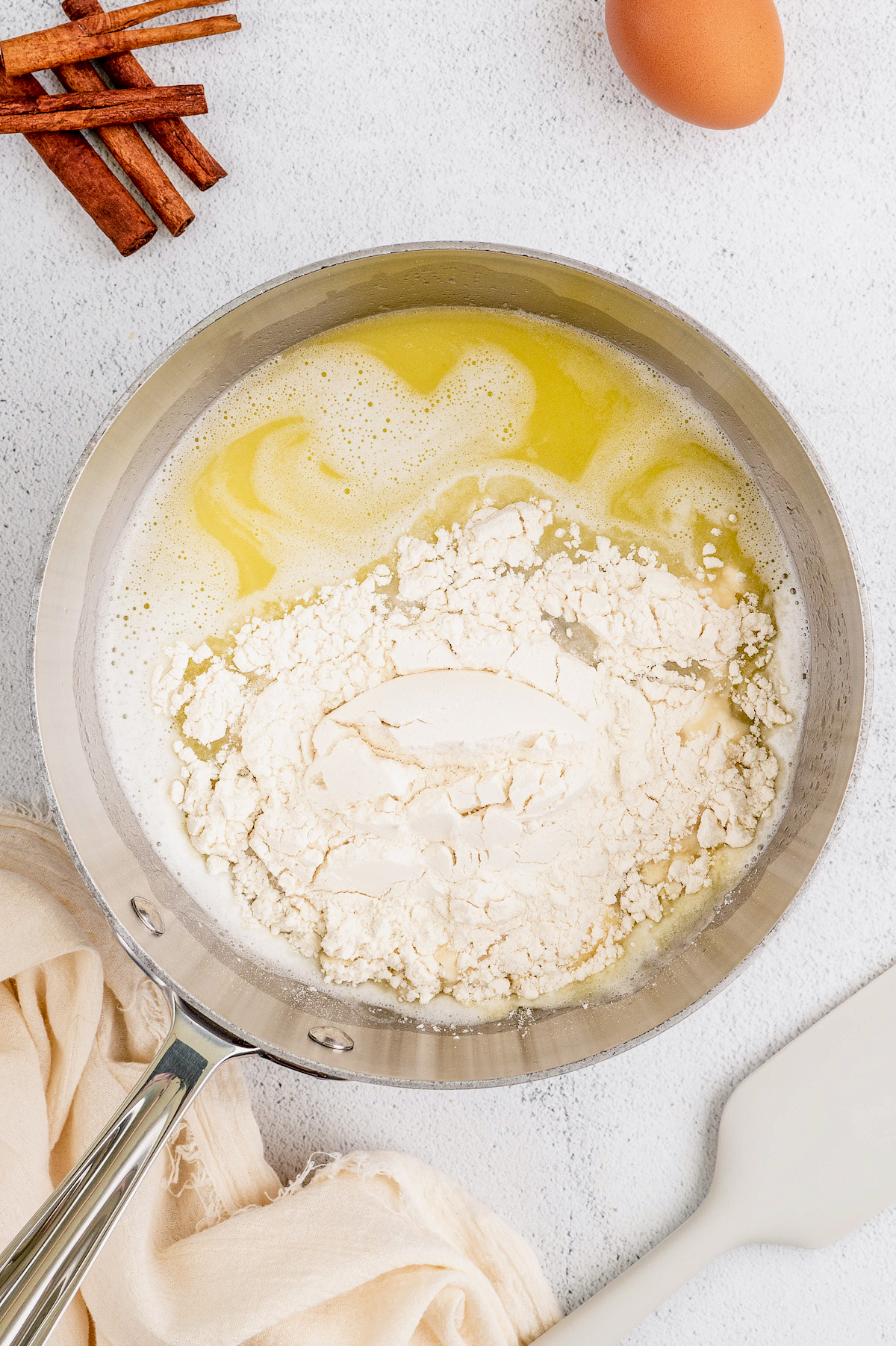 Adding the flour to the melted butter mixture in the pot.
