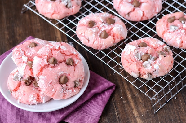 Strawberry Chocolate Chip Cookies on a white plate with remaining cookies on a rack