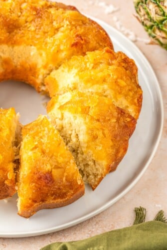 A bundt cake, partially cut into slices.