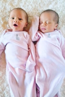 Newborn Twin Girls Laying on a Blanket in Long-Sleeved Pink Pajamas