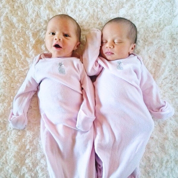 Newborn Twin Girls Laying on a Blanket in Long-Sleeved Pink Pajamas