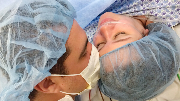 A Father Kissing a Mother on the Forehead After her C-Section