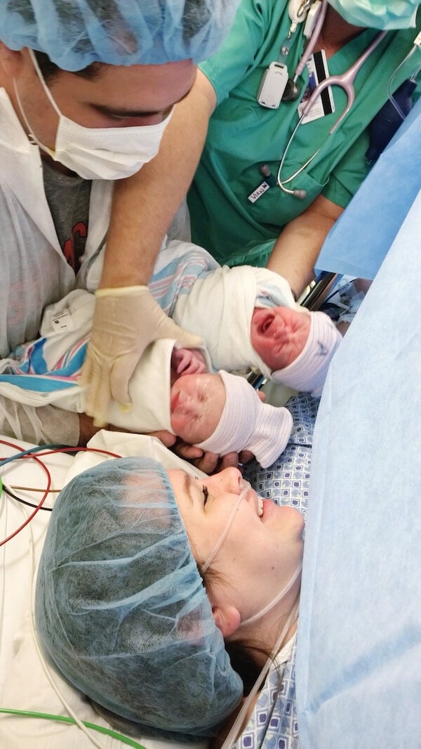 A Nurse Bringing Newborn Twins to the Mother and Father Right After Birth