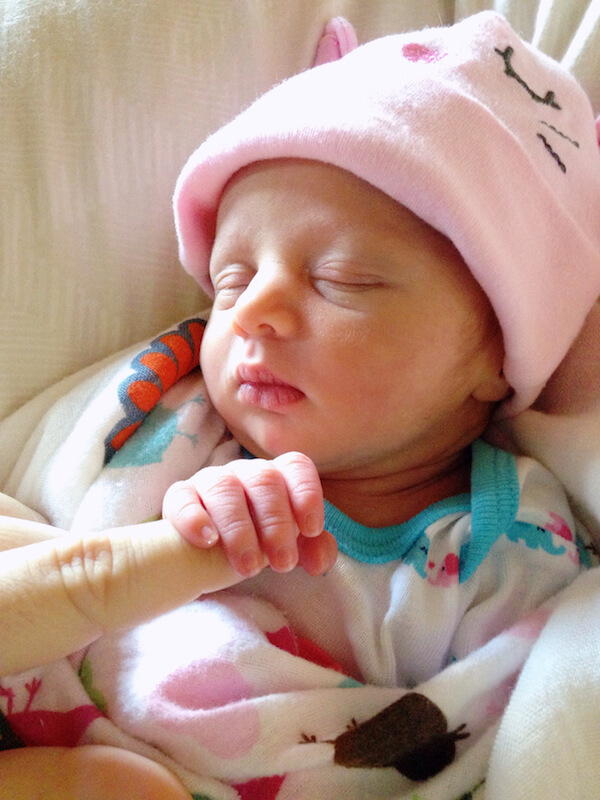 Baby Lyla in a Pink Hat Holding my Finger While she Sleeps
