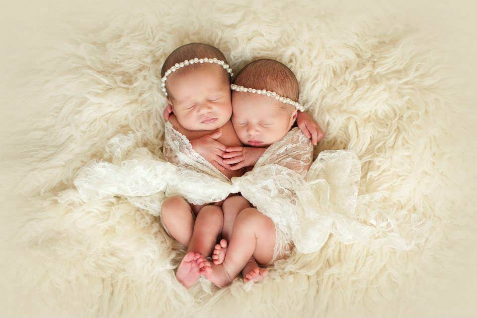 Two Newborn Baby Girls Cuddling on a Fluffy Blanket