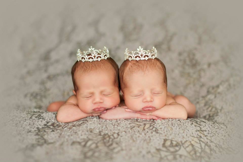 Newborn Twin Girls Sleeping on a Gray Blanket with Tiny Crowns on their Heads