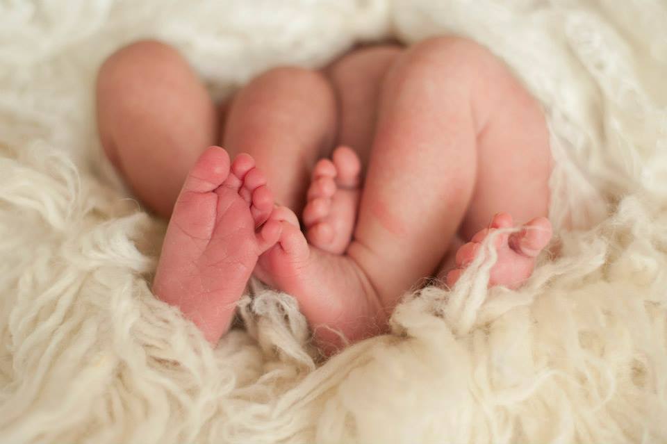 A Close-Up of Ellie and Lyla's Little Feet as they Sleep on a Fluffy Off-White Blanket