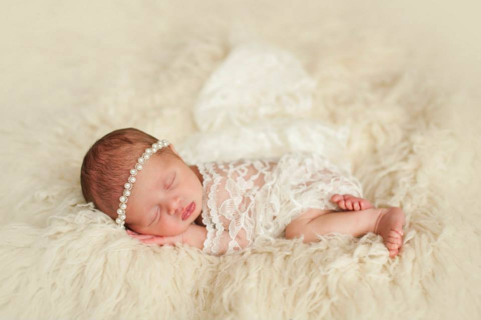 A Sleeping Baby Girl with White Lace Draped Over Her
