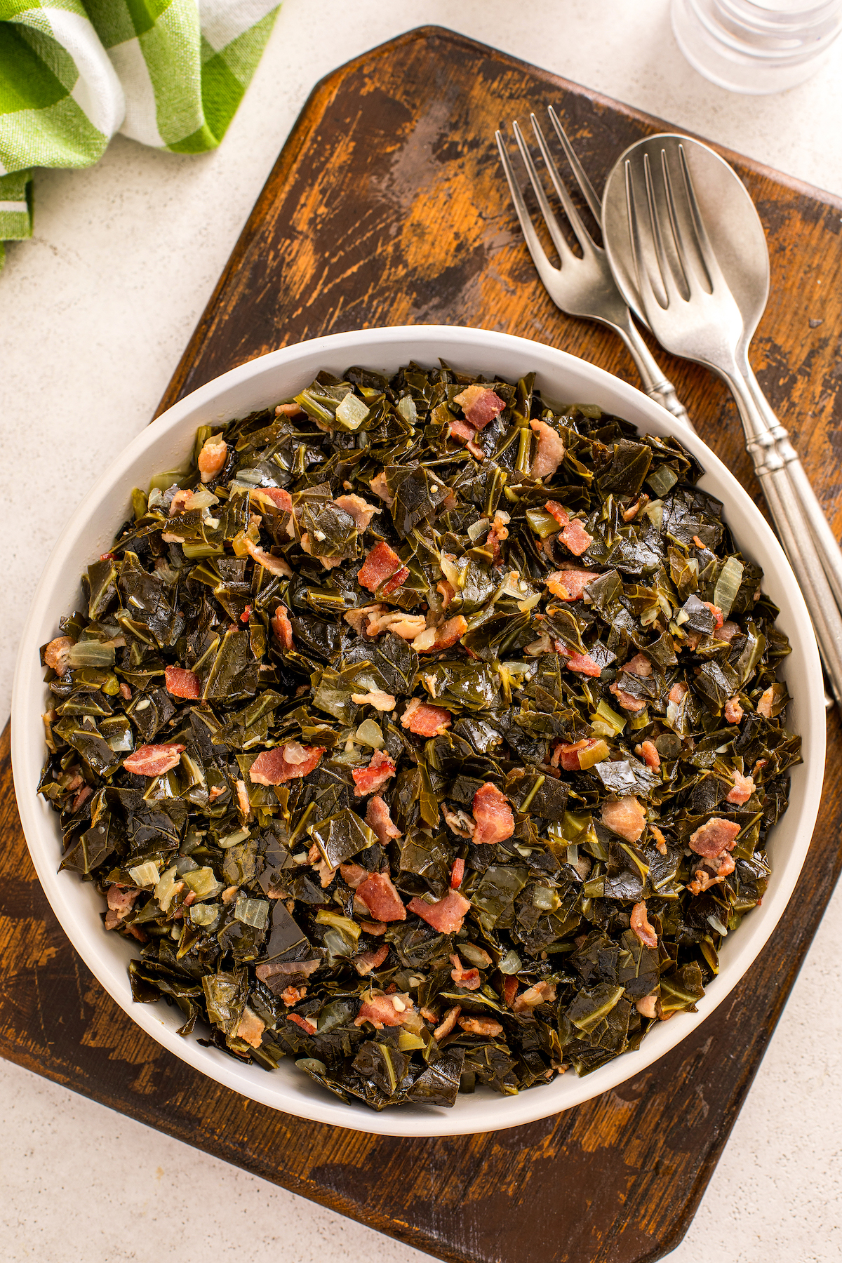 Beer-simmered, garlicky collard greens with smokey bacon in a big bowl.