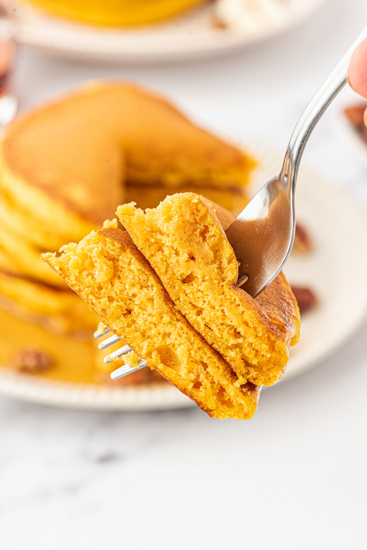 a fork with a bite of pumpkin pancakes