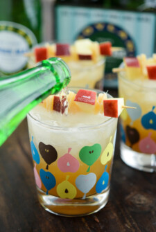 Spiked Apple Cider Being Slowly Poured Into a Glass with an Apple Design on it