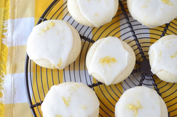 Seven Lemon Meltaway Cookies on a Black Cooling Rack on Top of a Plaid Yellow Tablecloth