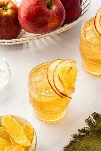 Three apple cider cocktails on a white background.