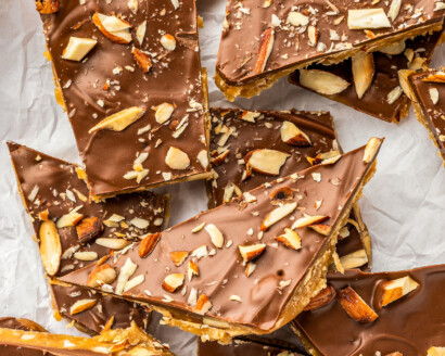 Broken pieces of Almond Roca bark candy on a white background.