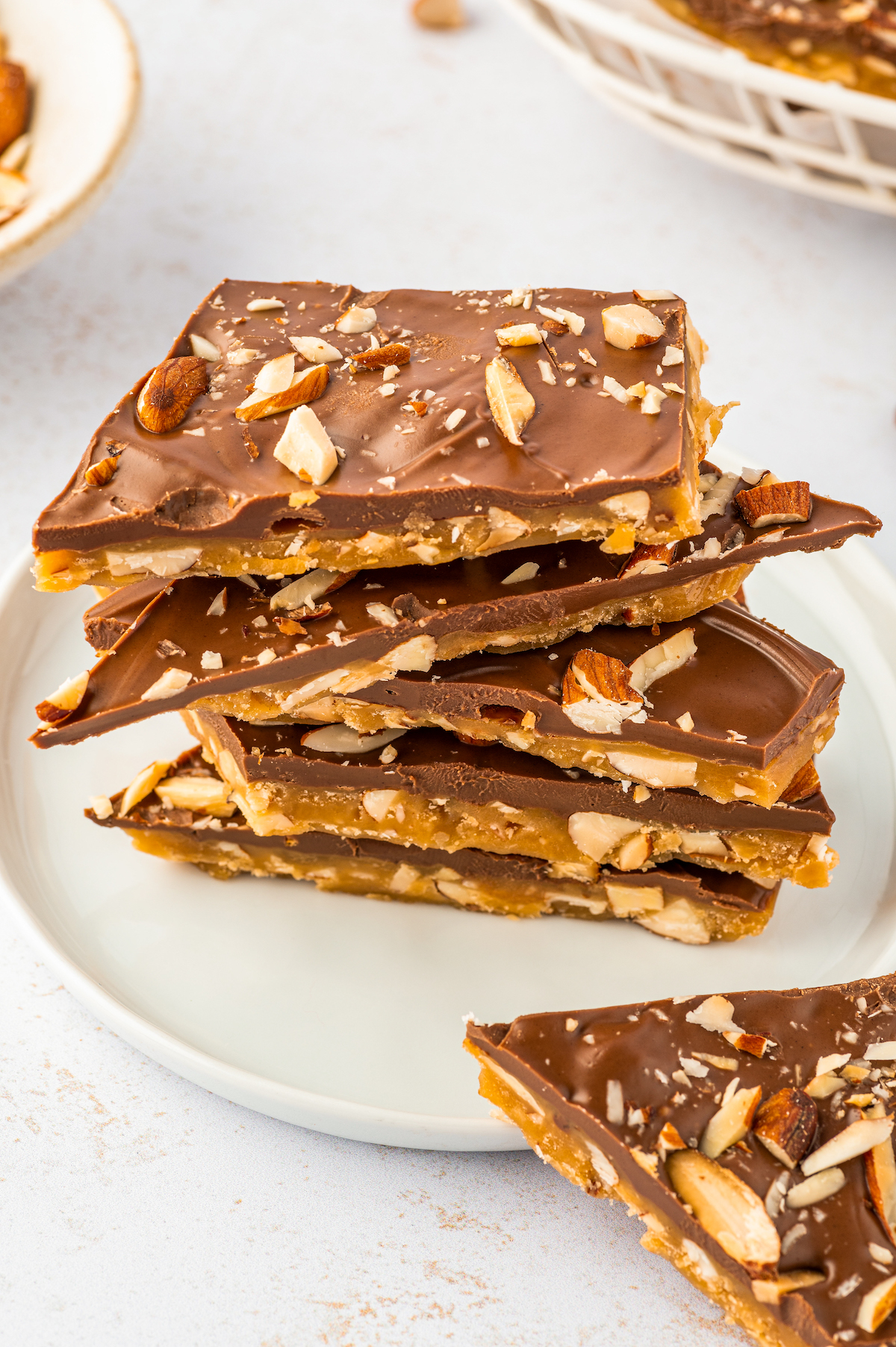 Pieces of chocolate almond toffee candy stacked on top of each other.