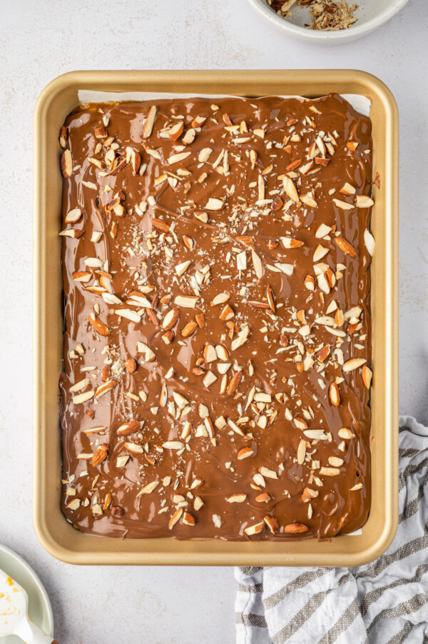 Chocolate toffee almond bark cooling in a 9x13 pan.