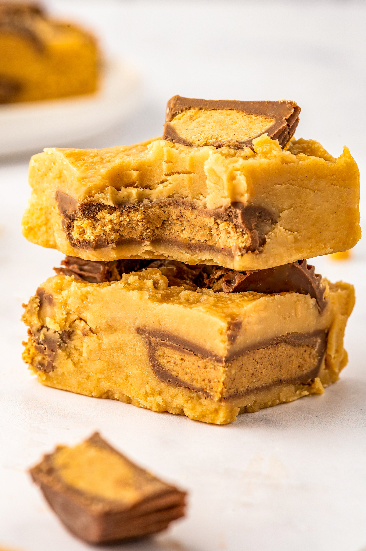 Bitten-into square of microwave peanut butter fudge stacked on top of a second piece of fudge. 