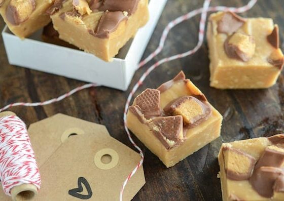 Squares of Microwave Peanut Butter Cup Fudge on a Table with a Roll of Red and White Twine