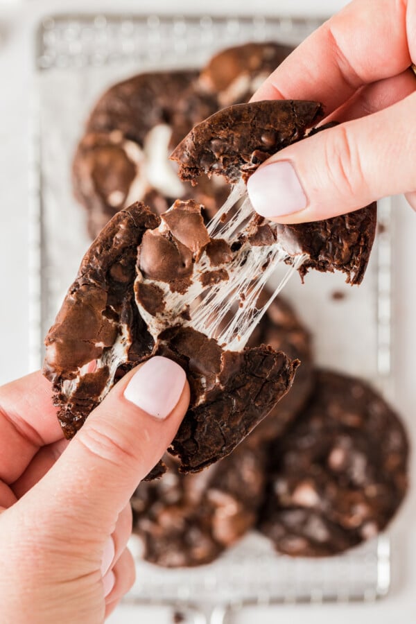 Pulling a chocolate marshmallow cookie apart to show the texture of the melted marshmallows.