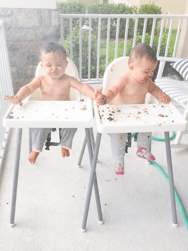 Twin Girls in Highchairs on a Front Porch Being Misted with Water