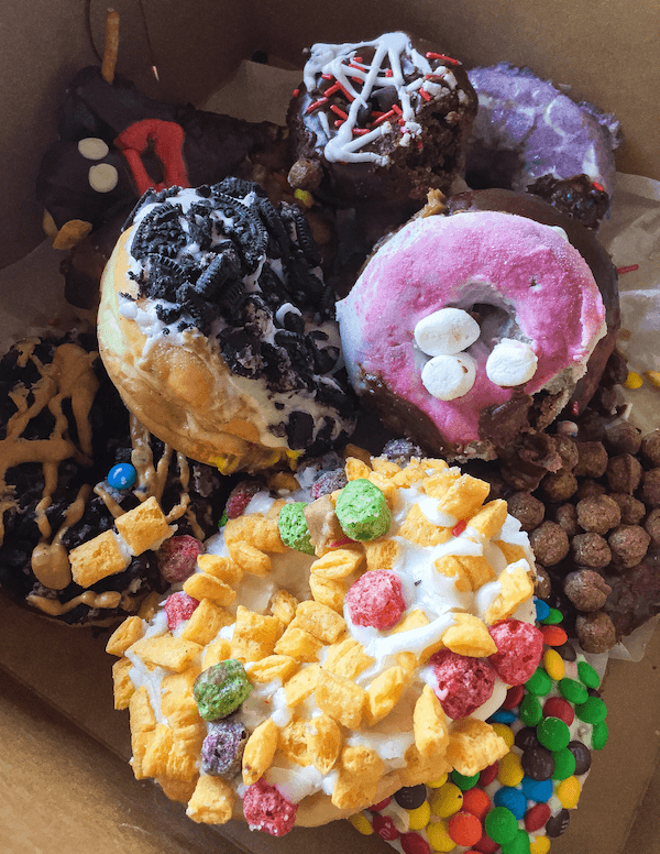 Various Doughnuts from Voodoo Donuts Inside of a Cardboard Box
