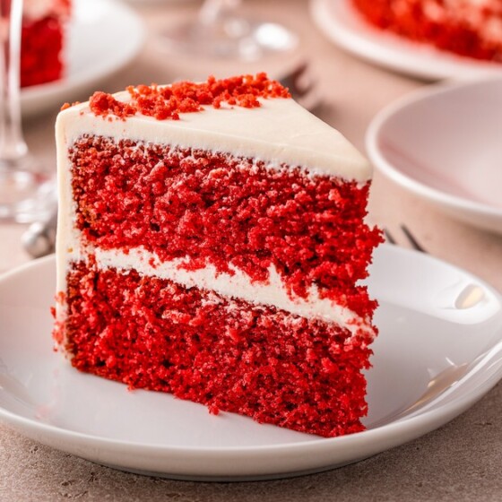 Sliced red velvet cake, served on white dessert plates.