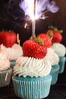 Red, White & Blue Sparkler Cupcakes topped with whole strawberry and a sparkler