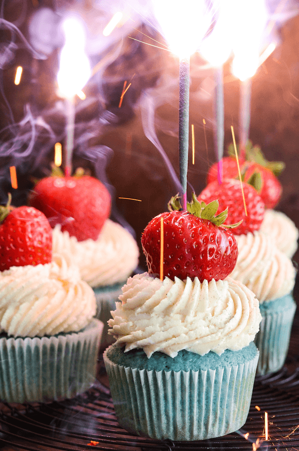 Red, White & Blue 4th of July Sparkler Cupcakes topped with whole strawberry and a sparkler