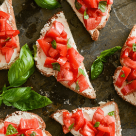 Slices of Tomato and Goat Cheese Toasts on a baking sheet
