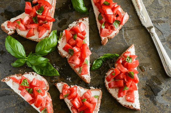 Slices of Tomato and Goat Cheese Toasts on a baking sheet