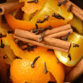 Cinnamon Orange Potpourri in a slow cooker crock with cloves, cinnamon sticks, and oranges