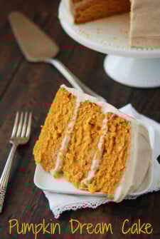 Slice of Pumpkin Dream Cake on a white plate. Full cake in the background.