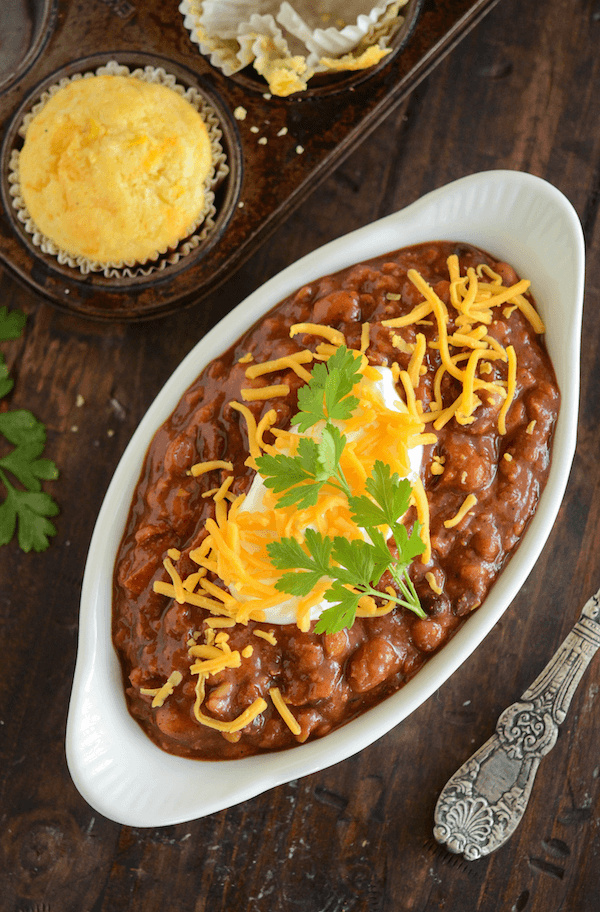 Slow Cooker Bean Chili and Easy Cornbread Muffins in an oval casserole dish