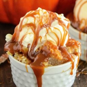 Caramel Apple Dump Cake in a jar with ice cream and caramel on top.