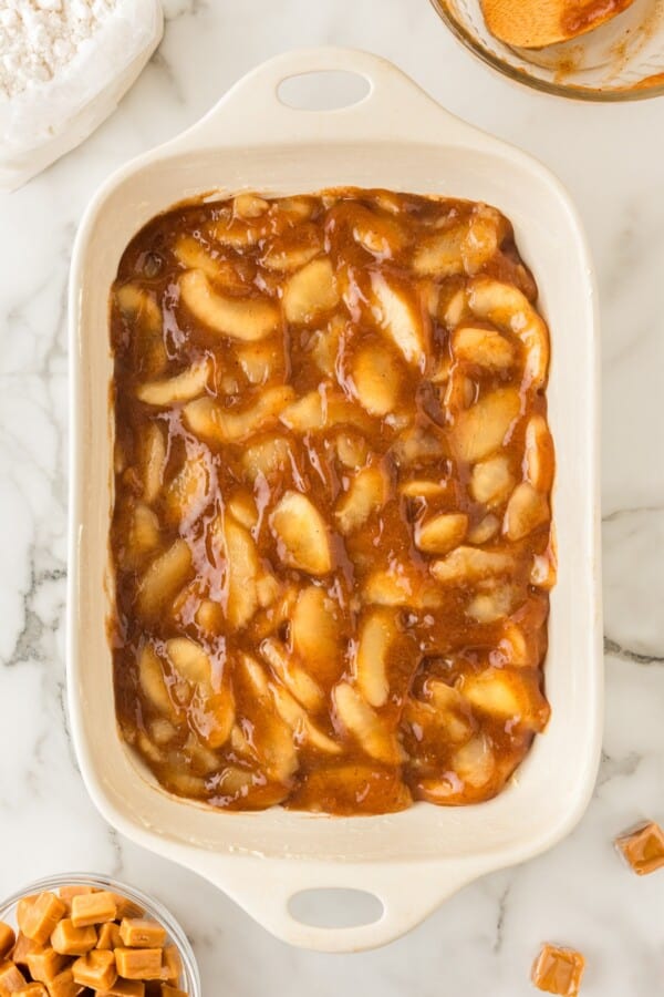 Spiced apple filling spread in an even layer in a baking dish.