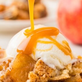 Caramel sauce is drizzled on top of ice cream and apple dump cake.