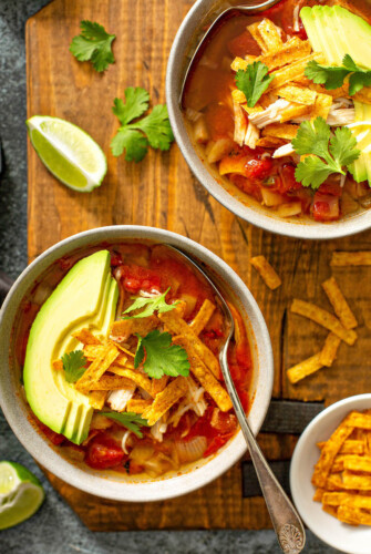 Chicken Tortilla Soup in bowls with avocado.