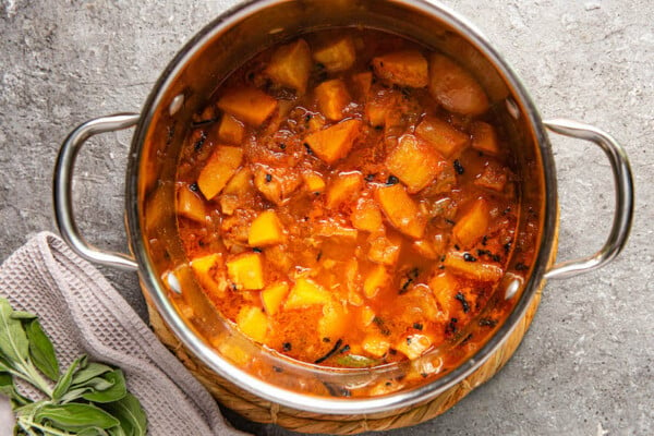 Pot filled with butternut squash, apple and broth.