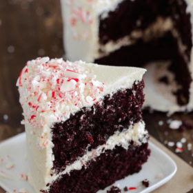 Close-up of a slice of layered chocolate peppermint cake with creamy frosting.