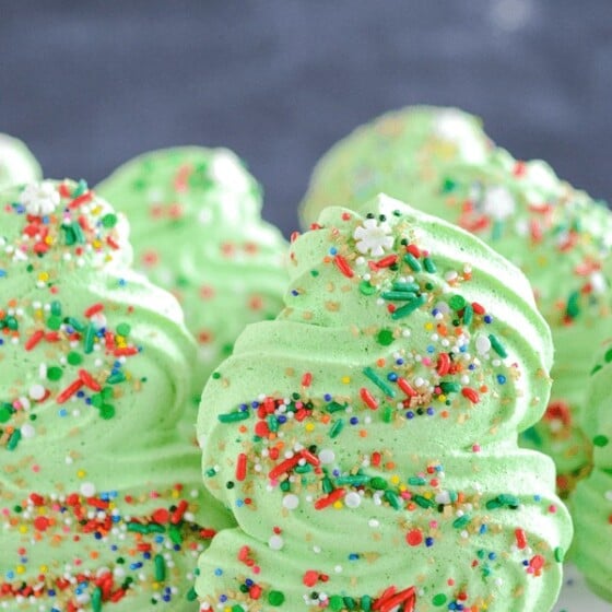 A Group of Christmas Tree Cookies on a Countertop Covered in Sprinkles