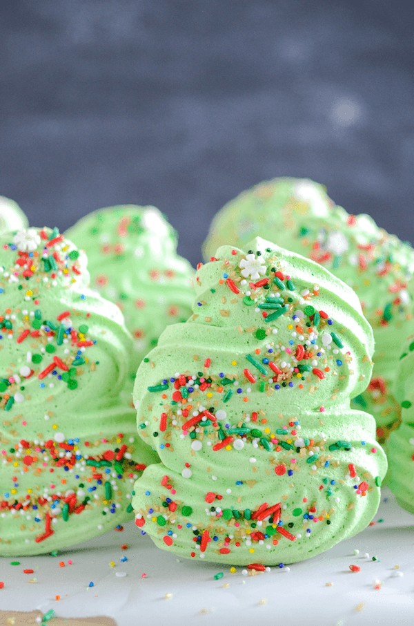 A Group of Christmas Tree Cookies on a Countertop Covered in Sprinkles